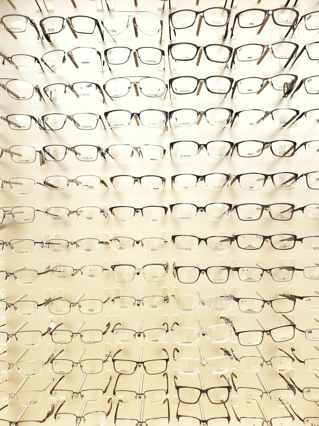 Verschiedene Brillenmodelle an einer weißen Wand im Optikergeschäft.